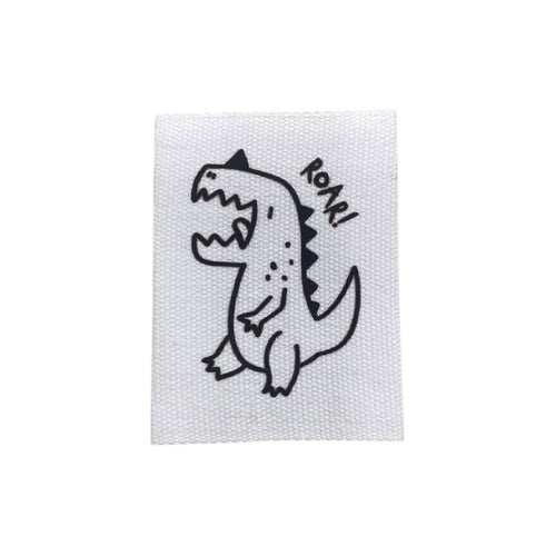 Baumwolllabel mit Aufdruck "weißer Dino und ROAR!" in schwarz auf weißem Hintergrund