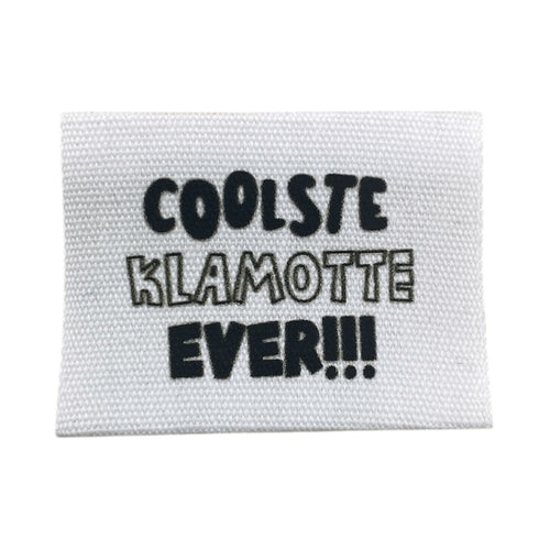 Baumwolllabel mit Aufdruck "coolste Klamotte ever!!!" in schwarz auf weißem Hintergrund