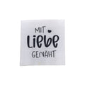Baumwolllabel mit Aufdruck "mit Liebe genäht" in schwarz auf weißem Hintergrund
