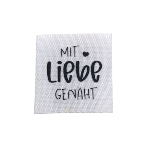 Baumwolllabel mit Aufdruck "mit Liebe genäht" in schwarz auf weißem Hintergrund